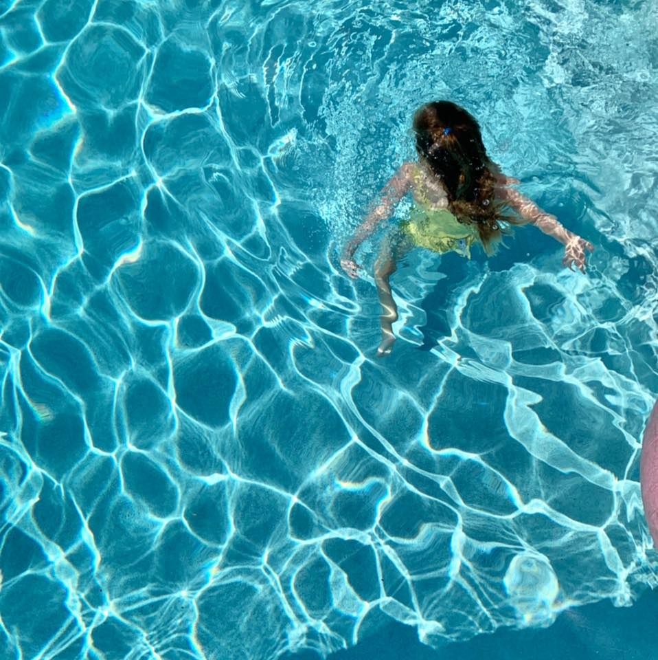 Overhead view of a swimmer in sparkling blue pool water